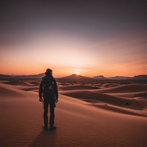 A captivating photograph of a solo adventurer silhouetted against a breathtaking sunset in the desert, mirroring the essence of embarking on a journey beyond the horizon.